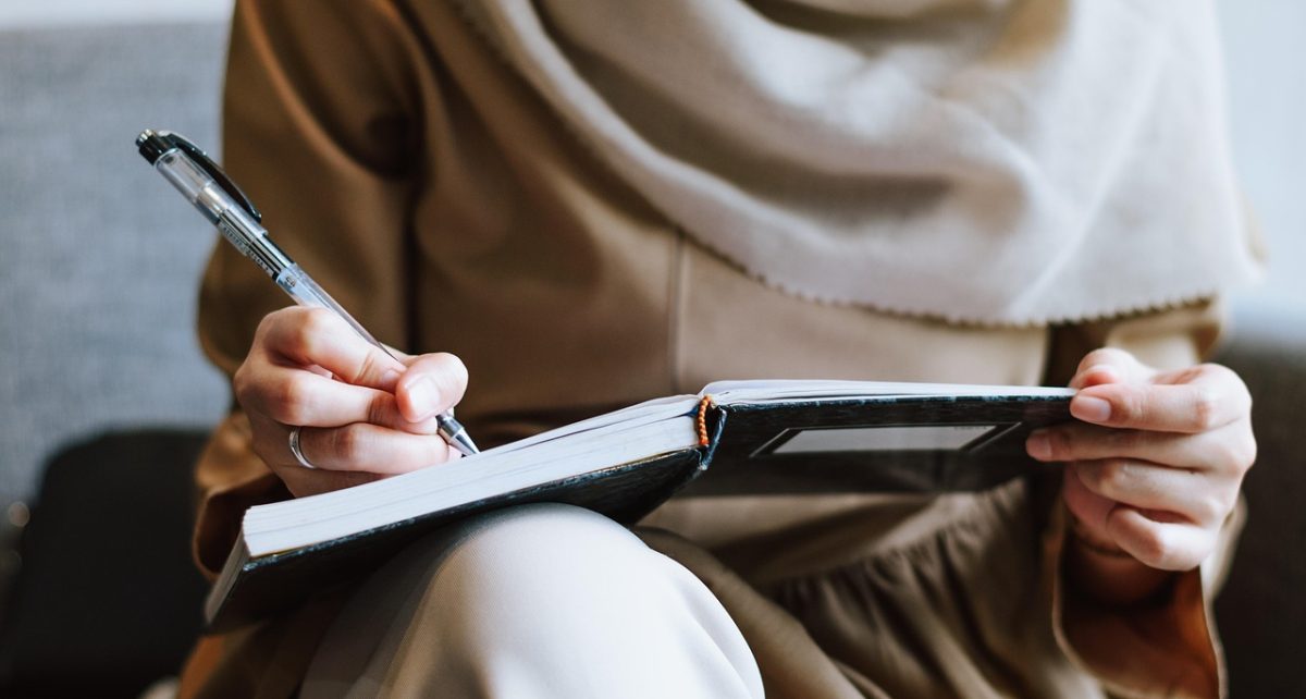 Muslim, woman, writing — "How a Forex Broker Facilitates Market Access and Efficient Trade Execution"