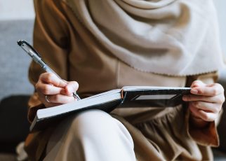 Muslim, woman, writing — "How a Forex Broker Facilitates Market Access and Efficient Trade Execution"